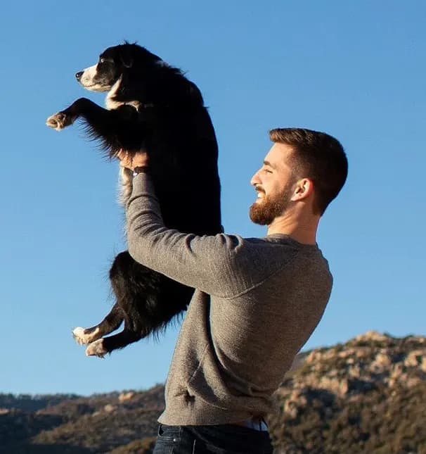 Marc holding up his dog Indy, with the Tucson hills behind them